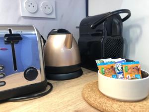 a counter top with a toaster and a box of food at Suite Bubbles Spa - Luxe - Centre Ville - calme - wifi in Troyes