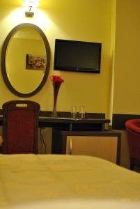 Habitación con espejo y mesa con sidx sidx sidx sidx en Hotel Dana en Amara