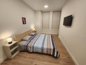 a bedroom with a bed and a tv on a wall at Deluxe 2 Bedroom VIP to NYC in Union City