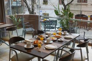einen Tisch mit Teller mit Lebensmitteln auf dem Balkon in der Unterkunft Sarum Hotel Design in Buenos Aires