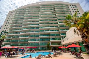 a large building with a swimming pool in front of it at Hotel Colon Salinas in Salinas