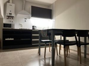 una cocina con mesa negra y sillas negras en ESTEPA, en Río Gallegos 6 fotos más