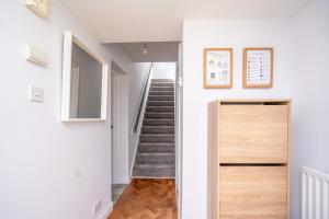 - un couloir avec une porte et des escaliers dans une maison dans l'établissement Spacious 5 Bedroom House - Sleeps 7 - 3-Car Driveway - Work - Leisure, à Wolverhampton