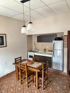a kitchen with a wooden table with chairs and a refrigerator at Departamento VILLA NUEVA in Villa María