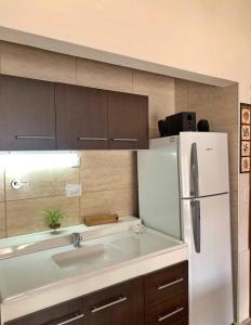 a kitchen with a white refrigerator and a sink at Departamento VILLA NUEVA in Villa María