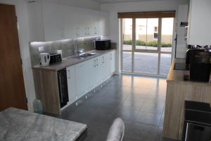 eine Küche mit weißen Schränken und einem Fliesenboden in der Unterkunft Haven - Spacious Luxury Home perfect for families, couples and contractors! 5mins to Xscape and Junction 32! in Castleford