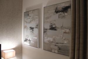 zwei gerahmte Bilder hängen an einer Wand neben einer Lampe in der Unterkunft Haven - Spacious Luxury Home perfect for families, couples and contractors! 5mins to Xscape and Junction 32! in Castleford + 39 Fotos