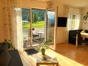 ein Wohnzimmer mit einem Sofa und einem großen Fenster in der Unterkunft Ferienwohnungen Apart Diana in Vils