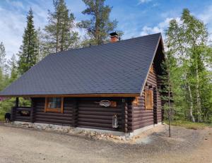 a log cabin with a man sitting on the roof at Saremökki in Kittilä