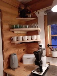 a kitchen with a coffee maker and cups on shelves at Saremökki in Kittilä