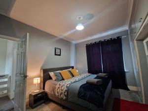 a bedroom with a bed with purple curtains and a window at Primos Place - 2 Bedroom in Ashington in Ashington