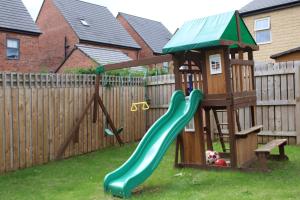a playground with a slide and a playset at Haven - Spacious Luxury Home perfect for families, couples and contractors! 5mins to Xscape and Junction 32! in Castleford