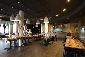 a restaurant with wooden tables and chairs in a room at KT&G Sangsangmadang Chuncheon Stay in Chuncheon