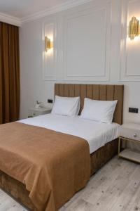 um quarto com uma cama grande e lençóis brancos em Parvana Guest House em Guiumri