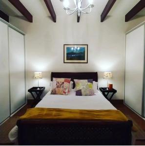 a bedroom with a large bed with two lamps at 6 Olives B&B in Darling