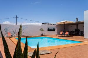 ein Schwimmbad in der Mitte eines Hauses in der Unterkunft Villa Dulce Celestino Lanzarote in Nazaret