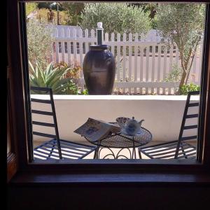 a table and two chairs and a vase on a porch at 6 Olives B&B in Darling