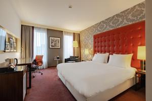 a hotel room with a large bed and a red headboard at Crowne Plaza Amsterdam - South by IHG in Amsterdam