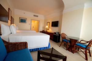 Hotel Colon Salinas في ساليناس: غرفة فندقية بسرير كبير وطاولة