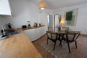 una cucina con tavolo in vetro e sedie in camera di Casa di Campara Villa Faro a Faro