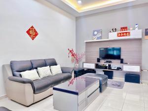 ein Wohnzimmer mit einem Sofa und einem TV in der Unterkunft Comfort Holiday Home 8-14pax Bayau Lagoon Water Park in Malakka