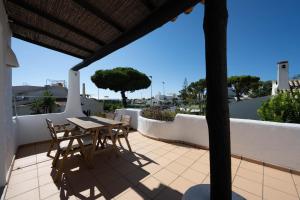 un patio con tavolo e sedie sul balcone. di Casa di Campara Villa Faro a Faro