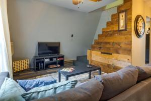 ein Wohnzimmer mit einem Sofa und einem TV in der Unterkunft A-Frame Cabin in Rocky Mount with Furnished Deck! in Rocky Mount
