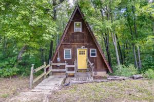 eine kleine Hütte im Wald mit gelber Tür in der Unterkunft A-Frame Cabin in Rocky Mount with Furnished Deck! in Rocky Mount