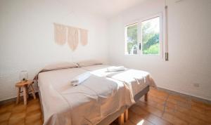 a white room with a bed and a window at BFA - R149 Casa adosada Alorda con piscina comunitaria in Calafell