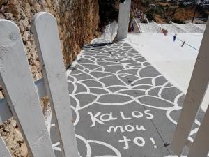 un panneau sur un trottoir qui indique klos now to sidx sidx sidx dans l'établissement Vasiliki Skyros Castle View, à Skiros