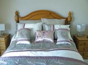 a bedroom with a large bed with pillows at The Caraneal in Plymouth