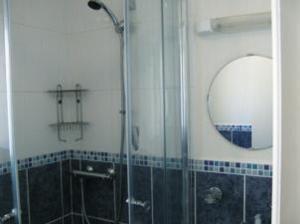 ein Bad mit einer Dusche und einem Spiegel in der Unterkunft The Caraneal in Plymouth