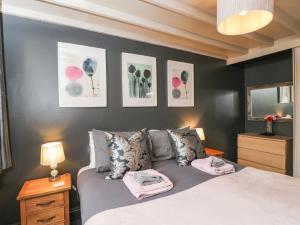 um quarto com uma cama com toalhas cor-de-rosa em Paddock Cottage em Malmesbury