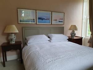 um quarto com uma cama branca com três fotografias na parede em Ballyteige Lodge em Ballyteige Bridge