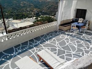 a balcony with a blue and white floor and chairs at Vasiliki Skyros Castle View in Skiros