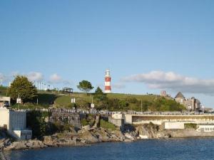 un faro en una colina junto a un cuerpo de agua en The Caraneal en Plymouth