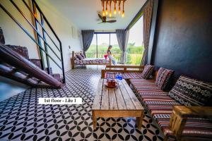 峰牙的住宿－Nguyen Shack - Phong Nha Resort，客厅配有沙发和桌子
