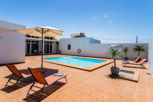 eine Terrasse mit Stühlen und einen Pool an einem Haus in der Unterkunft Villa Dulce Celestino Lanzarote in Nazaret