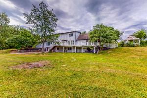 a large white house on a hill with a yard at Jenkins Farmstead in Woodburn