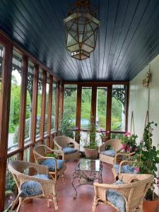 a screened in porch with chairs and a chandelier at Ballyteige Lodge in Ballyteige Bridge
