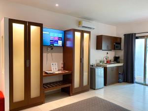 a kitchen with wooden cabinets and a refrigerator at Maia Suites Cozumel in Cozumel