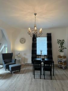a dining room with a table and a chandelier at Luxury Apartment Amina in Siedlung Schönwalde