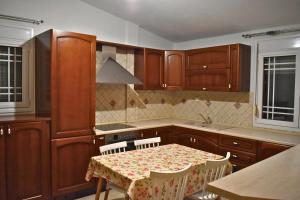 a kitchen with wooden cabinets and a table with chairs at Babis House in Limenaria
