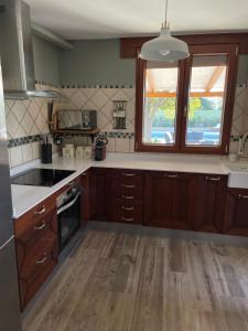 a kitchen with wooden cabinets and a sink and a window at El Refugio de Haro in Haro