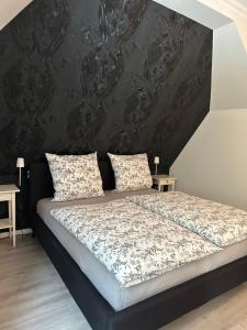 a bedroom with a bed with a black wall at Luxury Apartment Amina in Siedlung Schönwalde