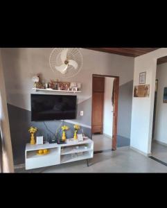 een woonkamer met een televisie en een wit entertainmentcentrum bij casa temporada da Cris in Paraty