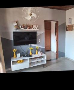 a living room with a television on a white entertainment center at casa temporada da Cris in Paraty