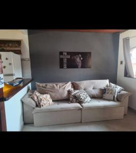 un sofá en una sala de estar con almohadas en casa temporada da Cris, en Paraty