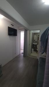 een woonkamer met een bank en een televisie aan de muur bij (3) Cuarto confortable en la mejor zona de Puebla. in Tlazcalancingo