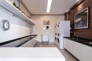 uma cozinha com um lavatório e um frigorífico branco em Predio completo com piscina no Itaim Bibi proximo a Faria Lima - Upper Itaim em São Paulo